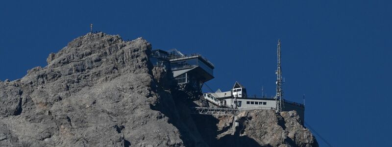 Das vergoldete Gipfelkreuz ist mit Aufklebern zugepflastet. (Archivbild)   - Foto: Angelika Warmuth/dpa