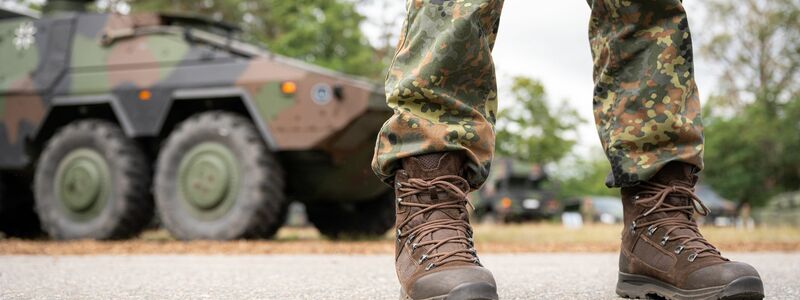 Ein Bundeswehrsoldat steht vor einem Militärfahrzeug (Symbolbild). - Foto: Mohssen Assanimoghaddam/dpa