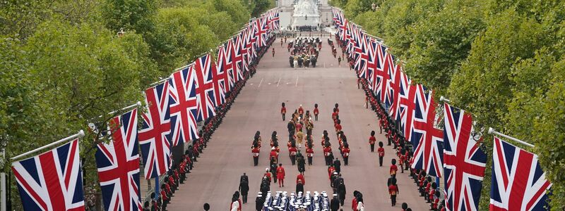 Der Trauerzug mit dem Sarg der gestorbenen britischen Königin Elizabeth II. fährt nach dem Gottesdienst über die Prachtstraße The Mall. - Foto: Zac Goodwin/PA Wire/dpa