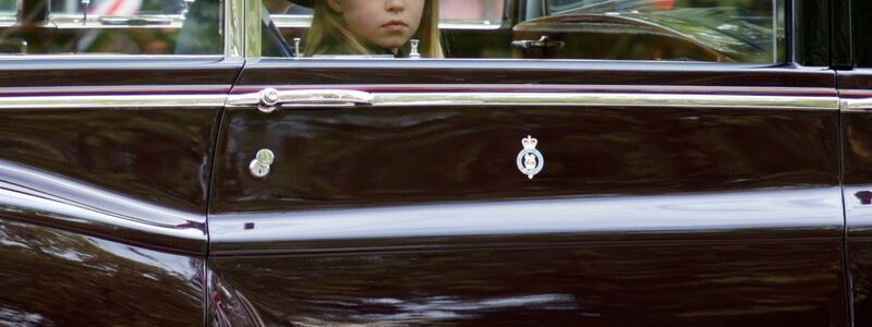 Prinzessin Charlotte sitzt am Tag des Staatsbegräbnisses von Königin Elizabeth II. in einem Auto neben ihrem Bruder Prinz George. - Foto: David Cliff/Pool AP/dpa