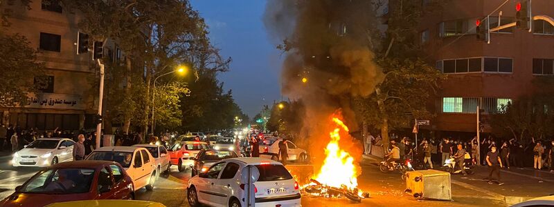 In Teheran brennt am Montagabend ein Polizeimotorrad. - Foto: Uncredited/AP/dpa