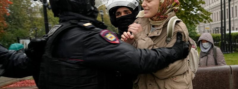 Bei einem Protest gegen die Teilmobilisierung in Moskau halten Polizisten eine Frau fest. - Foto: Uncredited/AP/dpa