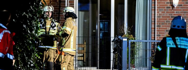 Einsatzkräfte der Feuerwehr stehen vor dem in Brand geratenen Altenheim in Wardenburg. - Foto: Hauke-Christian Dittrich/dpa