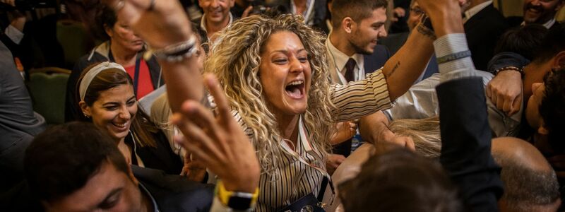 Anhänger der rechtsradikalen Partei Fratelli d'Italia (Brüder Italiens) jubeln während einer Pressekonferenz in der Wahlkampfzentrale der Partei. - Foto: Oliver Weiken/dpa
