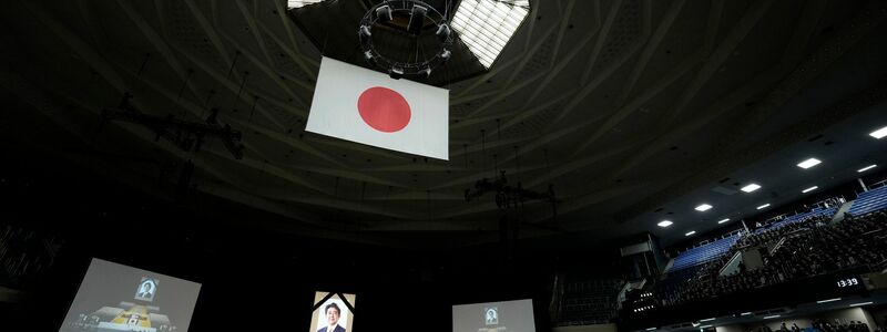 Gäste des Staatsbegräbnisses für Shinzo Abe sitzen in der Kampfsporthalle Nippon Budokan in Tokio. - Foto: Franck Robichon/Pool EPA/AP/dpa