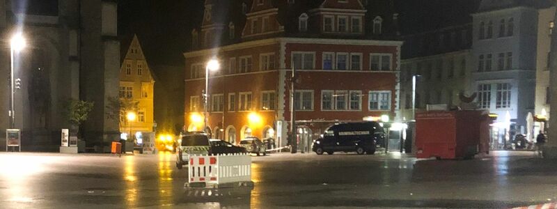 Polizeifahrzeuge stehen vor dem Marktschlösschen auf dem Marktplatz. - Foto: Wilhelm Pischke/dpa