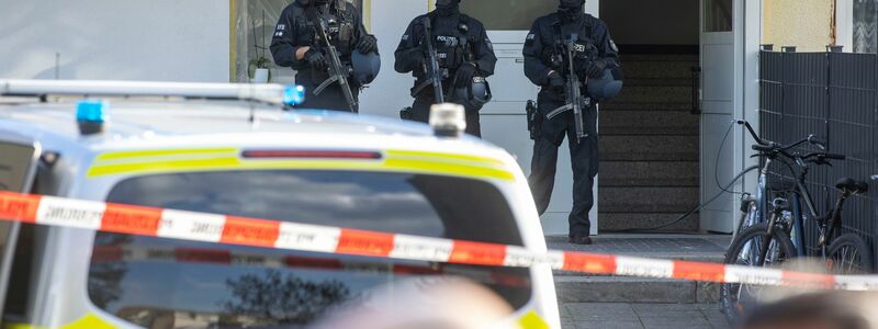 Polizisten stehen im Stadtteil Hackenbroich vor einem Kiosk. Hier wurde ein Mann erschossen. Die Polizei fahndete mit Dutzenden Beamten nach dem Schützen und nahm die Spurensicherung auf. - Foto: Christoph Reichwein/dpa