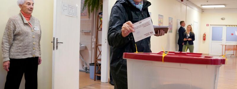 Eine Frau gibt ihre Stimme in einem Wahllokal in Riga ab. - Foto: Roman Koksarov/AP/dpa