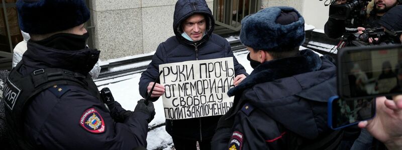 Russische Polizisten halten im vergangenen Dezember einen Mann fest, der vor dem Obersten Gerichtshof in Moskau gegen die Auflösung von Memorial protestiert: «Hände weg von Memorial, Freiheit für politische Gefangene.» - Foto: Pavel Golovkin/AP/dpa