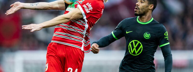 Augsburgs Fredrik Jensen (l) kommt vor dem Wolfsburger Paulo Otavio an den Ball. - Foto: Tom Weller/dpa