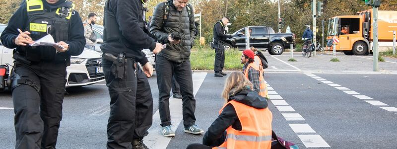 Bei einer Blockade der Gruppe Letzte Generation auf der Stadtautobahn unweit des Kurfürstendamms in Berlin wird ein Aktivist, der sich mit einem besonderen Gemisch auf die Straße festgeklebt hatte, mit schwerem Gerät von der Polizei von der Straße gelöst. - Foto: Paul Zinken/dpa