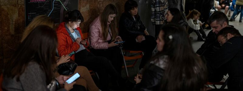 Menschen sitzen in einer Kiewer U-Bahn-Station, die als Luftschutzbunker dient. - Foto: Emilio Morenatti/AP/dpa