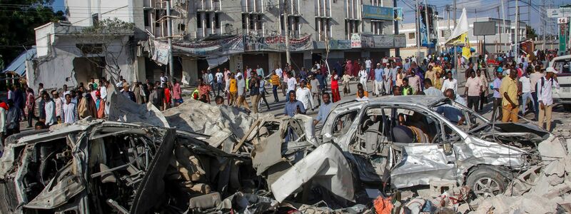 Angehörige  warten darauf, dass die Leichen von dem Ort entfernt werden, wo am Vortag zwei Autobomben an einer belebten Kreuzung in Mogadischu in Somalia eingeschlagen sind. - Foto: Farah Abdi Warsameh/AP/dpa