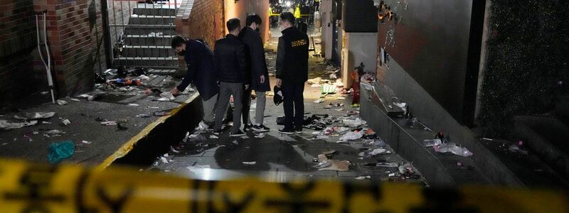 Polizisten inspizieren den Schauplatz, an dem Menschen in Seoul bei Halloween-Feiern gestorben sind. - Foto: Ahn Young-Joon/AP/dpa
