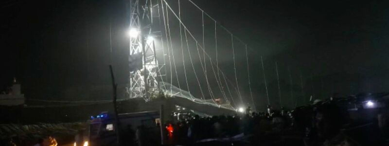 Rettungskräfte sind bei Dunkelheit im Einsatz, nachdem eine Brücke über dem Machchu-Fluss eingestürzt ist. - Foto: Rajesh Ambaliya/AP/dpa