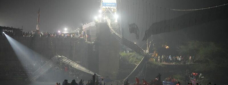 Eine jahrhundertealte Hängebrücke stürzte in den Fluss und riss Hunderte von Menschen in die Tiefe. - Foto: Ajit Solanki/AP/dpa