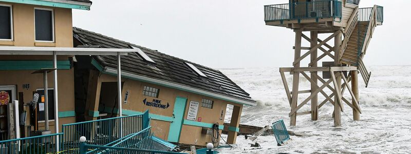 Ein Schild mit der Aufschrift «Schwimmen verboten» steht vor den Wellen in Daytona Beach. Der Sturm «Nicole» steuert auf die Ostküste der USA zu. - Foto: Paul Hennessy/SOPA Images via ZUMA Press Wire/dpa