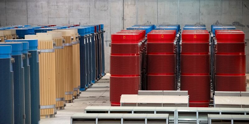 Behälter mit hochradioaktiven Abfällen und Transporthauben stehen im atomaren Zwischenlager Gorleben. - Foto: Sina Schuldt/dpa