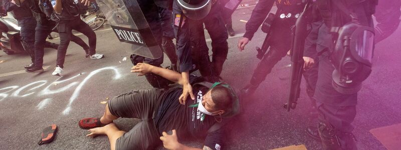 Polizisten im Clinch mit einem Demonstranten, der zusammen mit weiteren versucht, zum Veranstaltungsort des Apec-Gipfels zu gelangen. - Foto: Wason Wanichakorn/AP/dpa