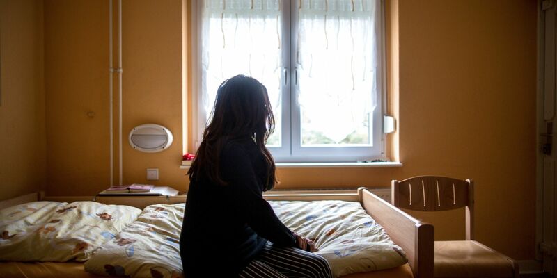 Eine Frau sitzt in einem Frauenhaus auf einem Bett. Tausende Frauen und Kinder haben auch 2022 zeitweilig Schutz in Schutzeinrichtungen gesucht. - Foto: Maja Hitij/dpa