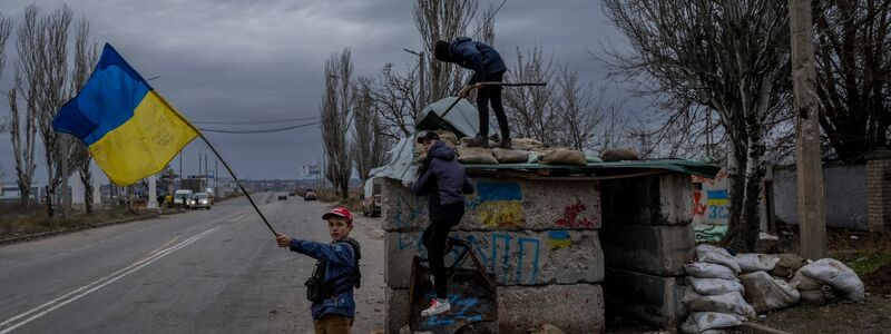 Ukrainische Kinder spielen an einem verlassenen Kontrollpunkt in Cherson. - Foto: Bernat Armangue/AP/dpa