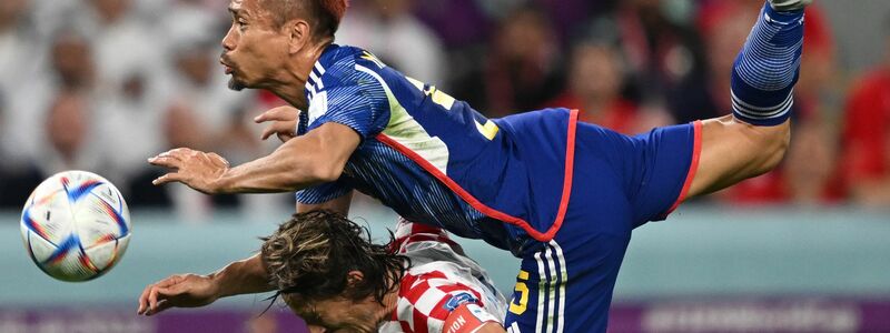 Kroatiens Luka Modric und Japans Yuto Nagatomo (oben) mit vollem Einsatz im Kampf um den Ball. - Foto: Robert Michael/dpa