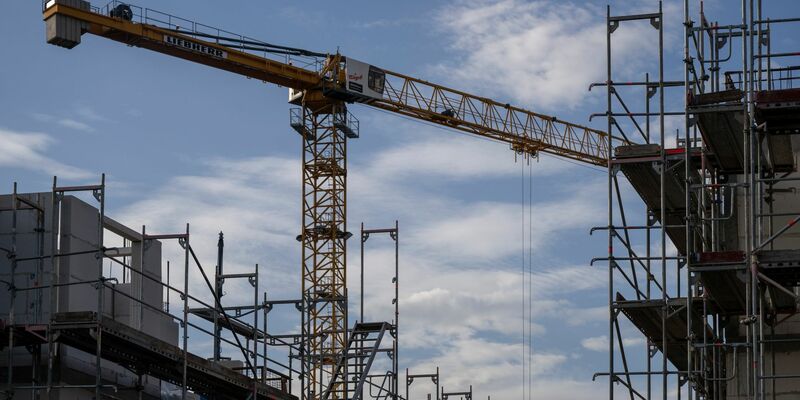 Ein Turmdrehkran ragt in den Himmel auf einer Baustelle: Das Baugewerbe ist vom Fachkräftemangel besonders stark betroffen. - Foto: Monika Skolimowska/dpa