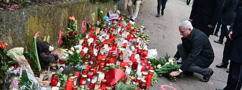 Kerzen und Blumen stehen am Tatort. - Foto: Bernd Weißbrod/dpa