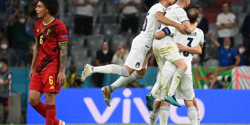 Während Italiens Spieler in München den Halbfinal-Einzug feiern, schaut Belgiens Axel Witsel (l) enttäuscht drein. - Foto: Federico Gambarini/dpa
