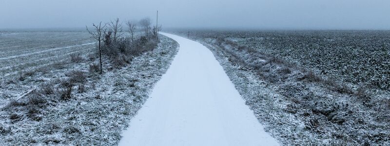 Ein von Schnee bedeckter Feldweg im Morgenlicht. - Foto: Silas Stein/dpa