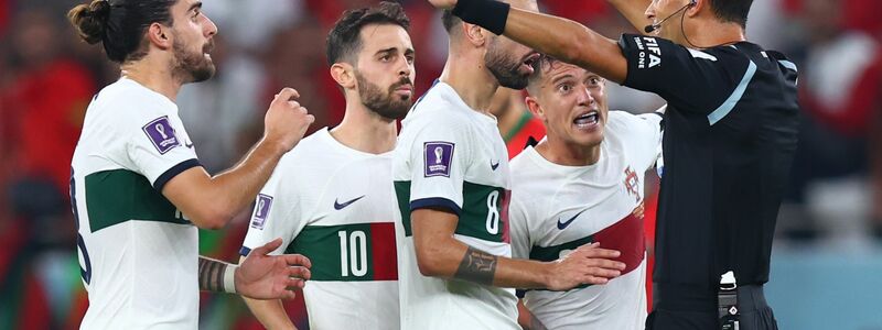 Portugiesische Spieler fordern von Schiedsrichter Facundo Tello einen Elfmeter. - Foto: Tom Weller/dpa