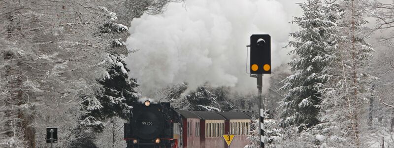 Ein Zug der Harzer Schmalspurbahn HSB fährt durch die verschneite Landschaft bei Drei-Annen-Hohne. - Foto: Matthias Bein/dpa