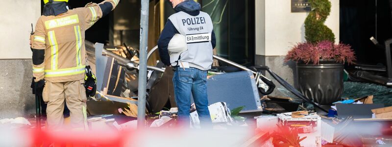 Ein Polizeibeamter begutachtet neben einem Feuerwehrmann die Trümmer vor dem Hotel auf der Karl-Liebknecht-Straße. - Foto: Christoph Soeder/dpa