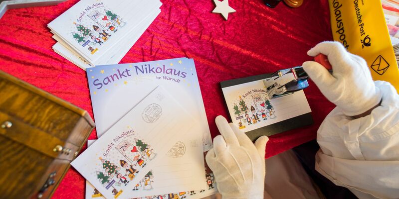 Der Nikolaus im Nikolauspostamt stempelt Briefe, die Kinder als Antwort auf ihre Briefe bekommen. - Foto: Oliver Dietze/dpa