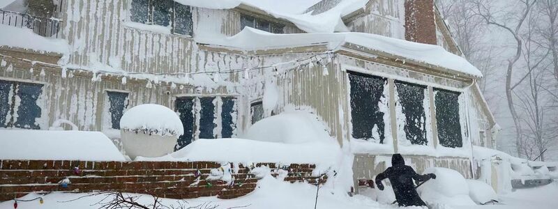 Ein Anwohner entfernt Schnee von einem Gebäude in Amherst. Amerika friert zum Weihnachtsfest weiter bei Schneestürmen und frostiger Kälte. - Foto: -/XinHua/dpa