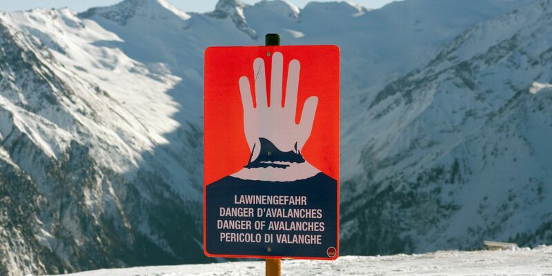 Ein Schild warnt in einem Skigebiet in den Alpen vor Lawinengefahr. - Foto: Frank Rumpenhorst/dpa