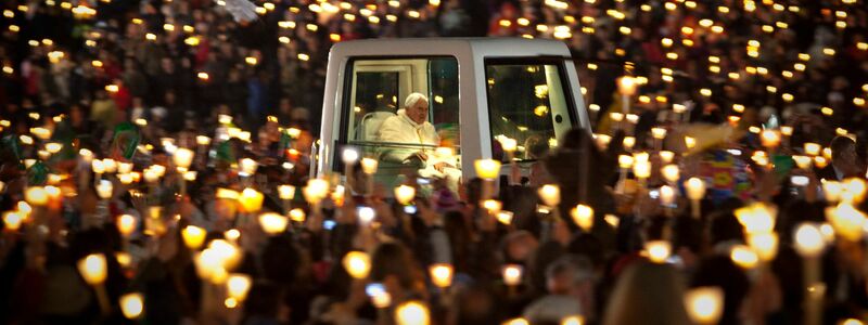 Der damalige Papst Benedikt XVI. fährt im Papamobil, als er das Heiligtum von Fatima verlässt (2010). - Foto: Emilio Morenatti/AP/dpa