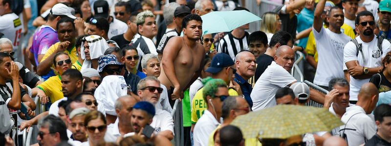 Zahlreiche Menschen warten vor dem Stadion des FC Santos, um Abschied von Pelé zu nehmen. - Foto: Matias Delacroix/AP/dpa