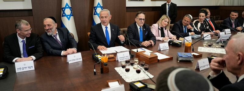 Der israelische Ministerpräsident Benjamin Netanjahu (M) und sein Justizminister Jariv Levin (l) planen eine heftig umstrittene Justizreform. - Foto: Ariel Schalit/AP POOL/dpa