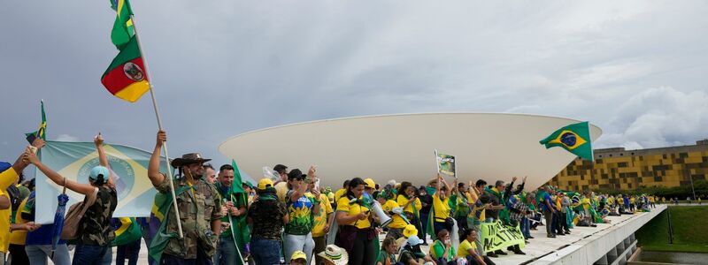 Bolsonaro-Anhänger stehen auf dem Dach des Kongressgebäudes in Brasilia. - Foto: Eraldo Peres/AP/dpa