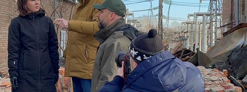 Annalena Baerbock im Gespräch mit dem ukrainischen Außenminister Dmytro Kuleba (3.v.r) in Charkiw auf dem Gelände eines den Russen zerstörten Umspannwerkes. - Foto: Jörg Blank/dpa
