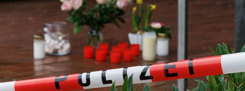 Blick auf Trauerkerzen und Blumen vor dem Eingang vom Berufskolleg Tecklenburger Land. - Foto: Friso Gentsch/dpa