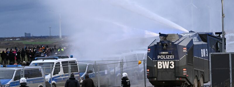 Die Polizei setzt einen Wasserwerfer ein. - Foto: Federico Gambarini/dpa