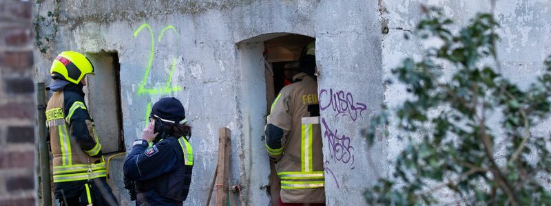 Einsatzkräfte stehen vor dem Gebäude, unter dem sich zwei verbliebene Aktivisten in einem Tunnel verschanzt hatten. - Foto: Thomas Banneyer/dpa