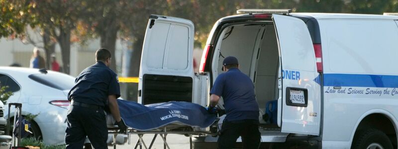 Die Leiche des mutmaßlichen Todesschützen wird vom Gerichtsmediziner des Bezirks Los Angeles aus einem Lieferwagen geholt. - Foto: Damian Dovarganes/AP/dpa