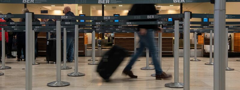 Ein Reisender geht mit einem Koffer zu einem Check-in-Schalter. Die Gewerkschaft Verdi hat für Mittwoch einen ganztägigen Warnstreik am Hauptstadtflughafen BER angekündigt. - Foto: Paul Zinken/dpa