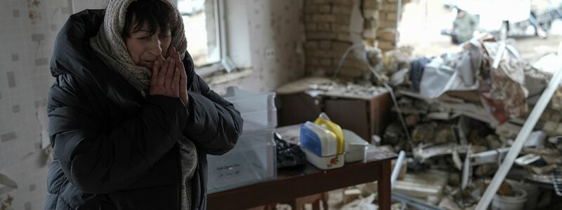 Halina Panasian steht nach einem russischen Raketenangriff in ihrem zerstörten Haus in Hlewacha. - Foto: Roman Hrytsyna/AP/dpa