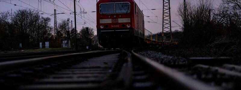 Die Lok mit Anhängern des Güterzuges steht auch am Morgen weiterhin auf den Gleisen. - Foto: Christoph Reichwein/dpa