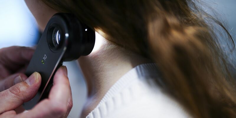 Ein Hautarzt untersucht bei einer Krebsvorsorgeuntersuchung eine Patientin mit einem Auflichtmikroskop. - Foto: Eva Manhart/APA/dpa