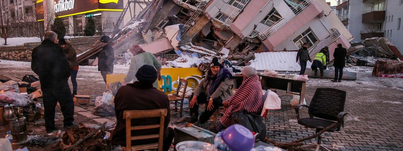 Türkische Rettungskräfte stehen an einem eingestürzten Gebäude. - Foto: Emrah Gurel/AP/dpa